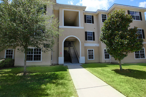 A well-maintained apartment building with landscaped lawns and a welcoming entrance.