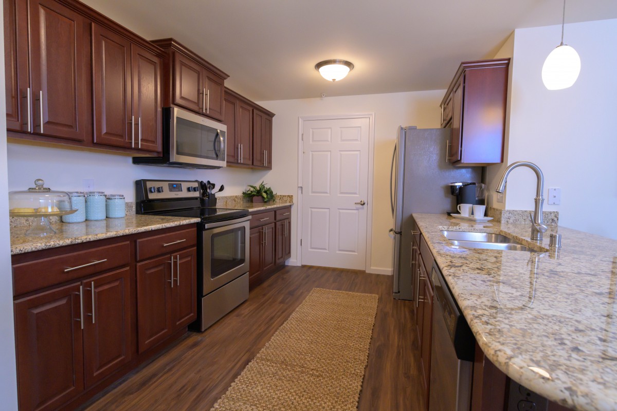 A modern kitchen with wooden cabinets and stainless steel appliances.