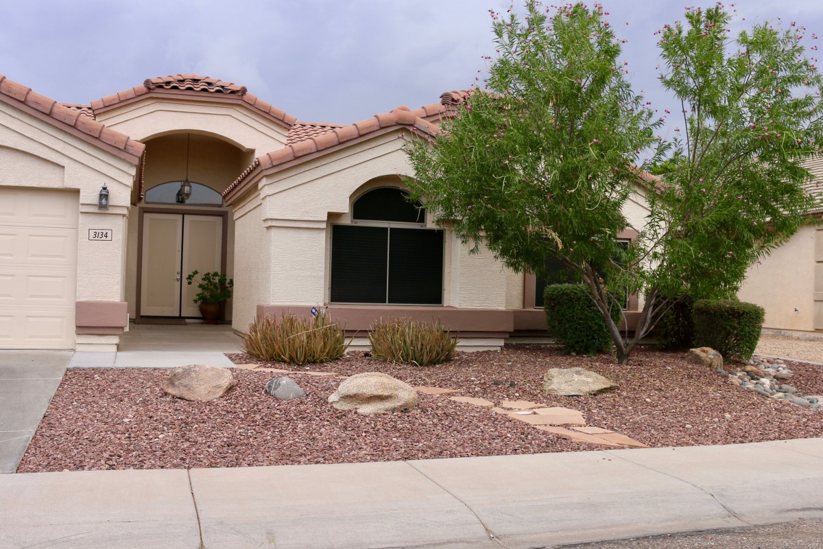 A suburban house with desert landscaping in the front yard.