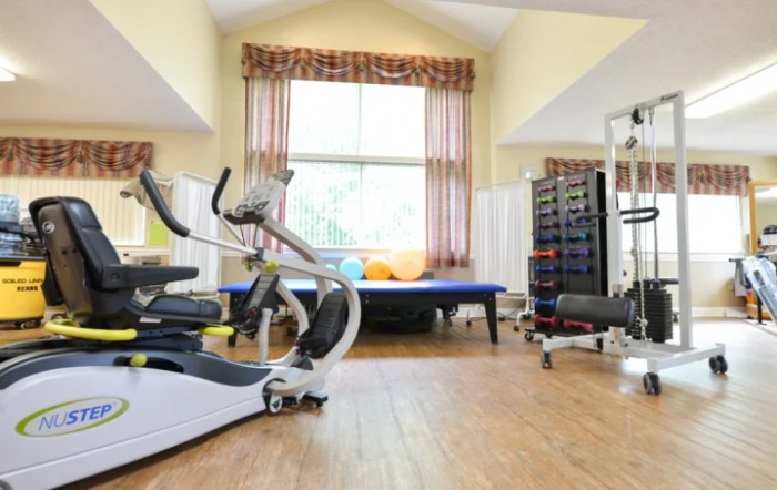 A spacious home gym featuring an elliptical machine and a variety of exercise equipment.