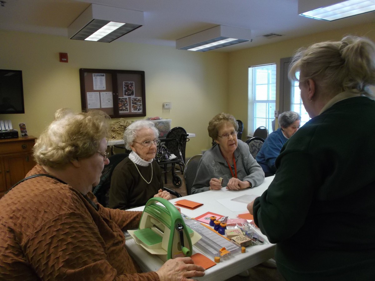 A group of seniors socializing around a table indoors.