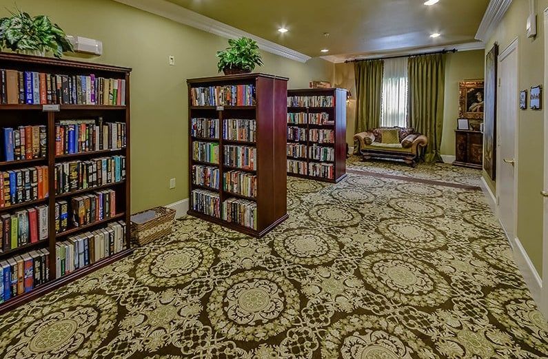 A cozy library room with bookshelves and a patterned carpet.