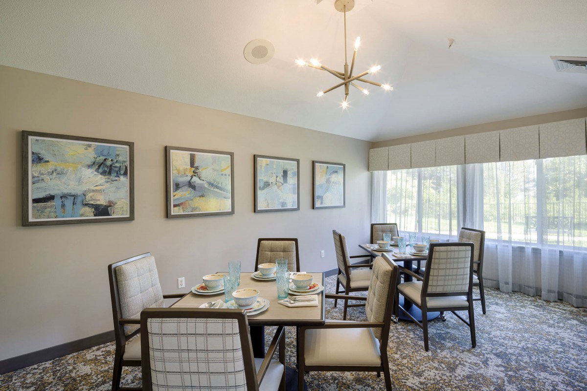 A well-decorated dining room featuring elegant furniture, wall art, and a modern chandelier.