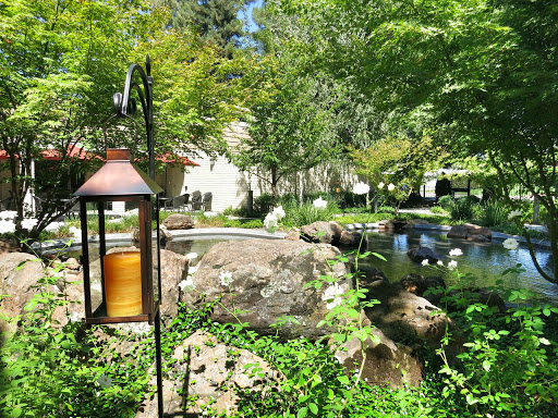 A serene garden retreat featuring a pond and lush greenery.