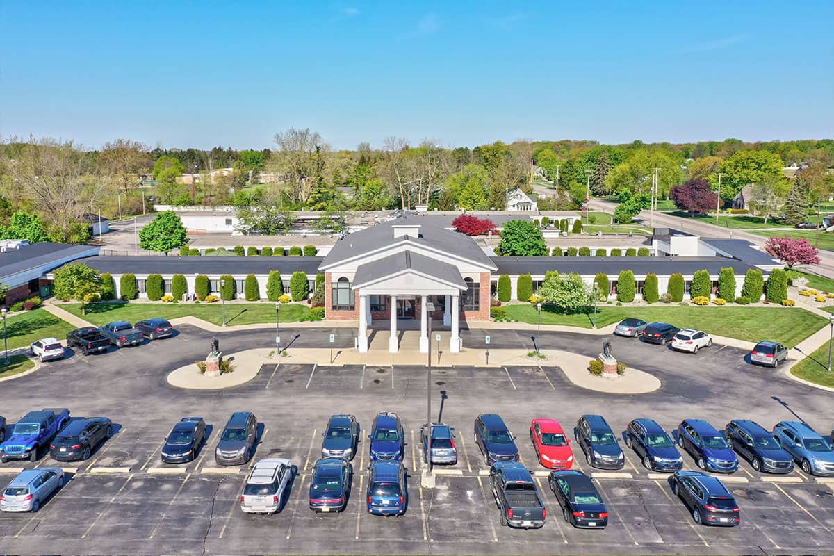 Aerial view of a large building with a parking lot in front.