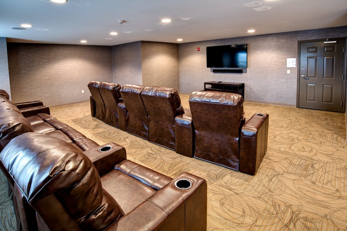 A cozy home theater setup with leather recliners facing a flat screen TV.
