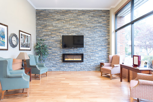 A modern living room featuring a stone accent wall, a fireplace, and comfortable seating.