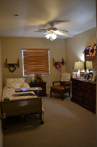 A cozy and well-decorated bedroom featuring a comfortable bed, a stylish chair, and warm lighting.