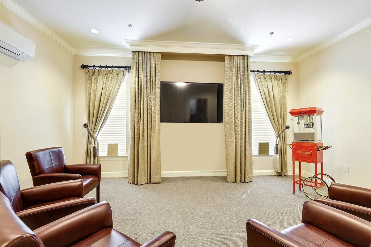 A cozy home theater setup with a television, leather seating, and a popcorn machine.