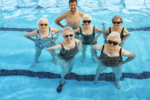 A group of seniors enjoying a fun session of water aerobics in the pool.