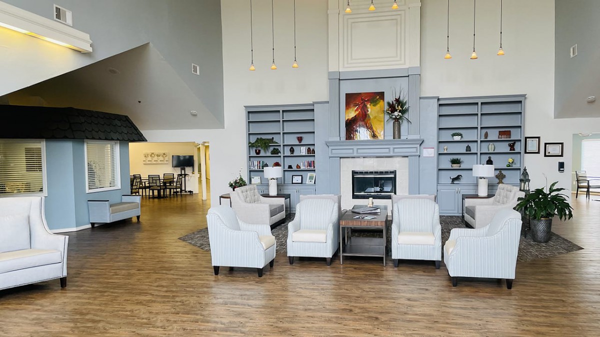 A modern living room with armchairs and a fireplace, featuring stylish interior design.