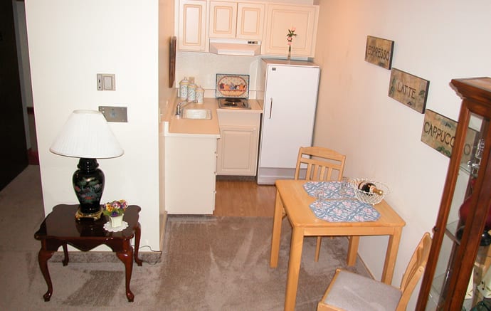 A compact kitchen and dining area in an apartment with simple furnishings.
