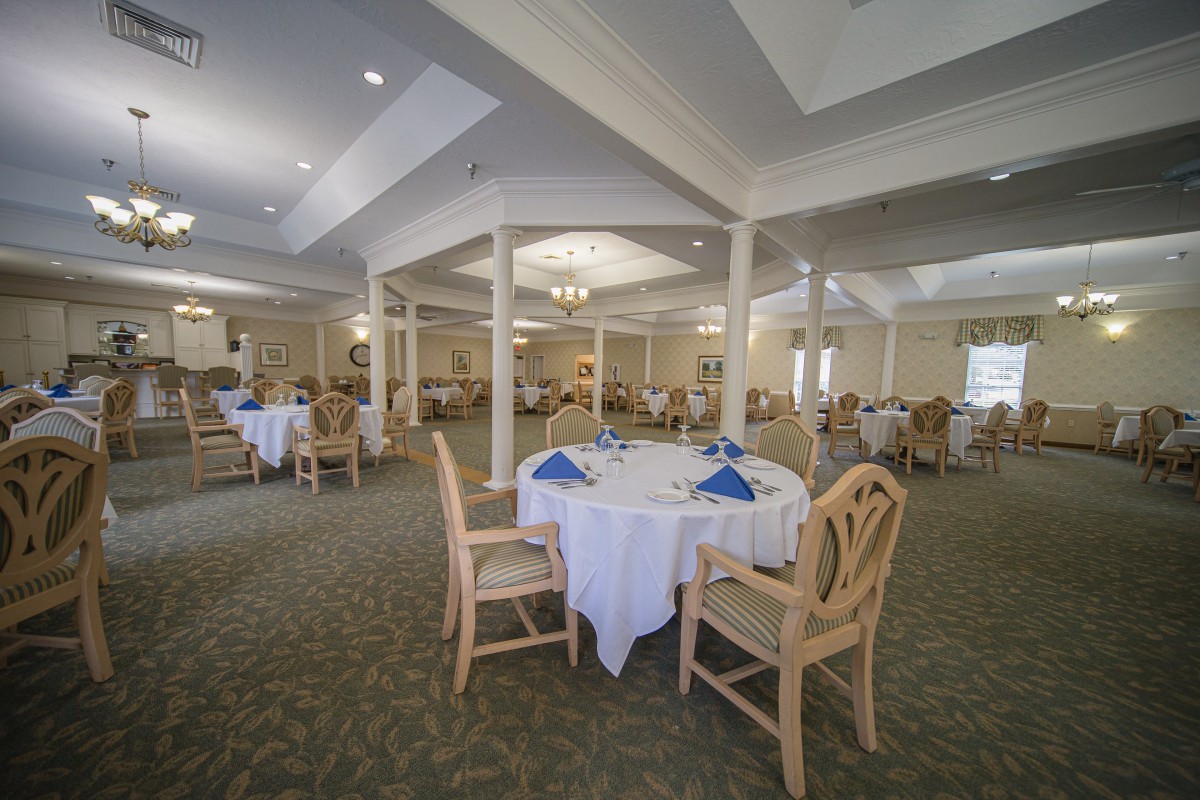Spacious dining area with elegantly set tables and comfortable seating.