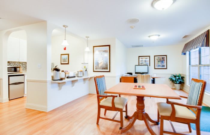 A modern kitchen and dining area with wooden flooring and bright lighting.