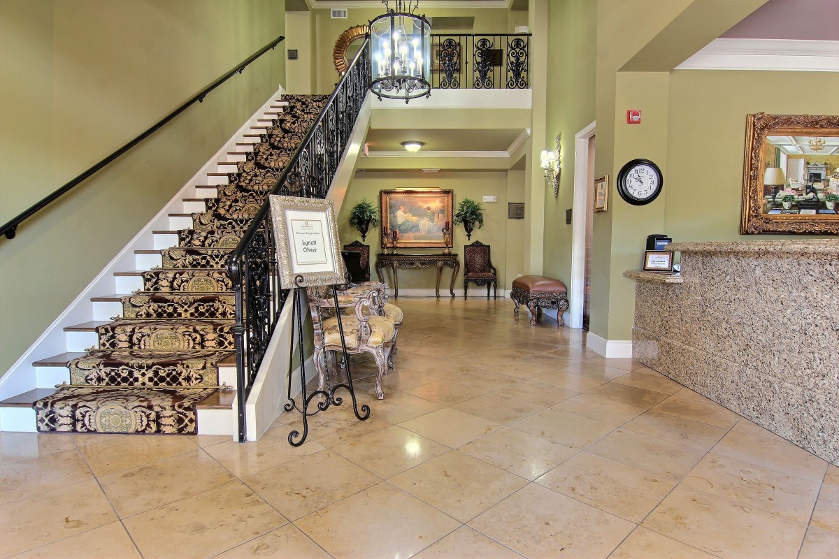 A spacious and elegantly designed hotel lobby featuring a grand staircase and chandelier.