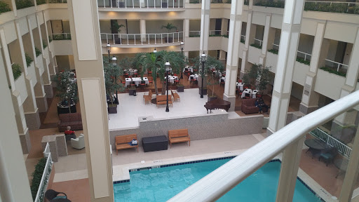 A serene indoor hotel environment featuring a pool and dining area.