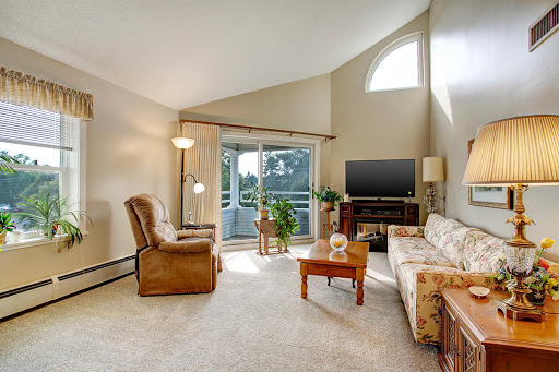 A cozy living room filled with natural light, featuring comfortable seating and modern decor.