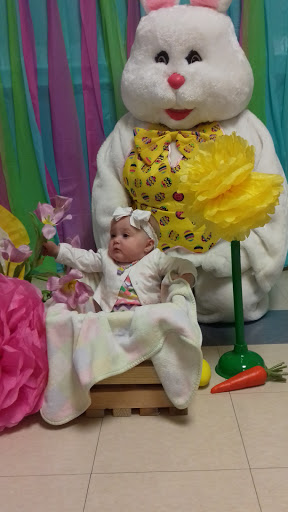 A cheerful baby surrounded by vibrant decorations and flowers, embodying the joy of spring festivities.