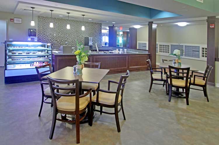 A modern cafe interior with tables, chairs, and a counter.