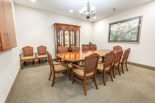 A spacious and elegantly designed meeting room featuring a large wooden table surrounded by comfortable chairs, perfect for formal discussions and gatherings.