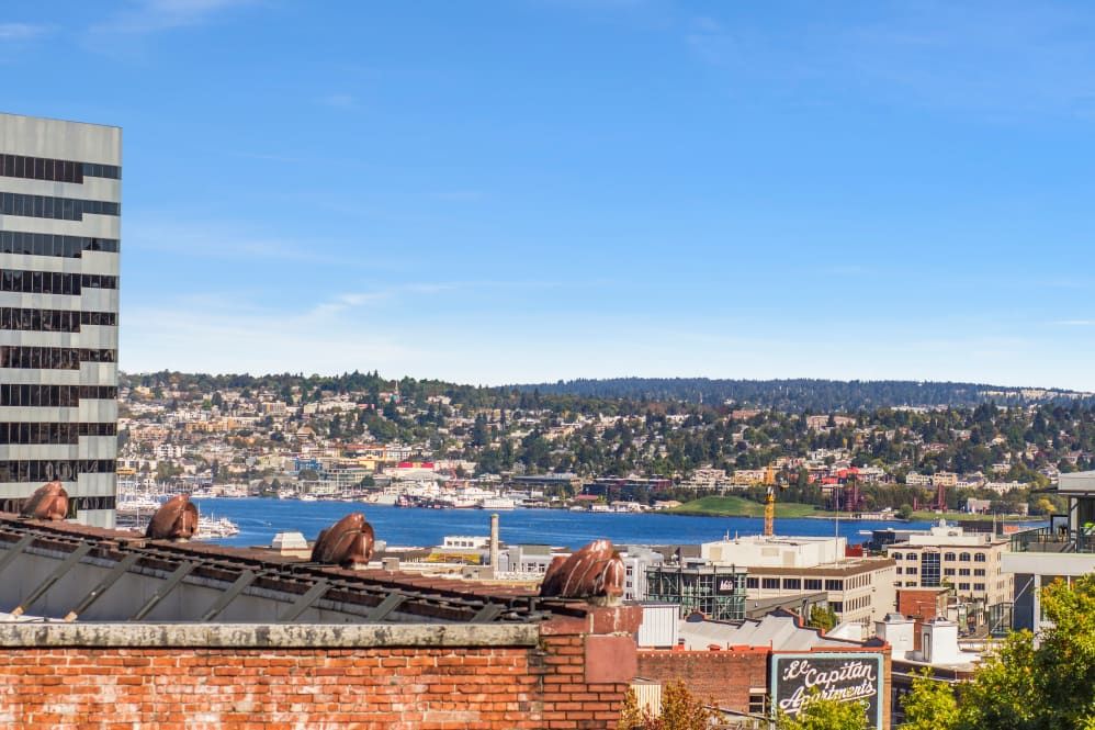 A scenic view of a city skyline with a lake in the foreground under a clear blue sky.
