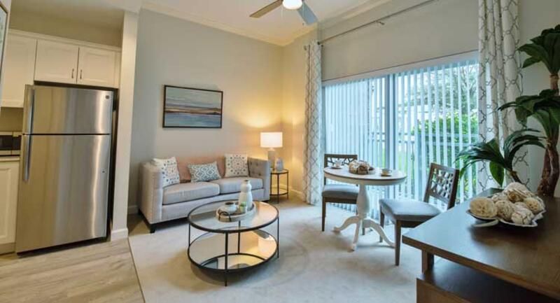 A modern living room with a cozy seating area, stylish coffee table, and a dining nook by the window.