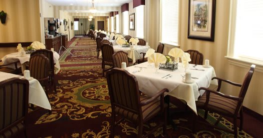 An elegantly decorated dining room with neatly arranged tables and chairs.