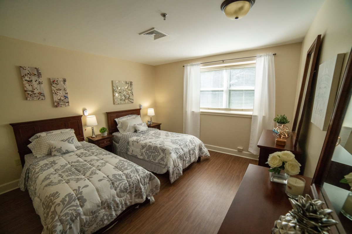 A cozy bedroom with two twin beds, soft lighting, and elegant decor.