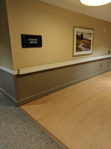 A view of a hallway featuring a sign and artwork on the wall.