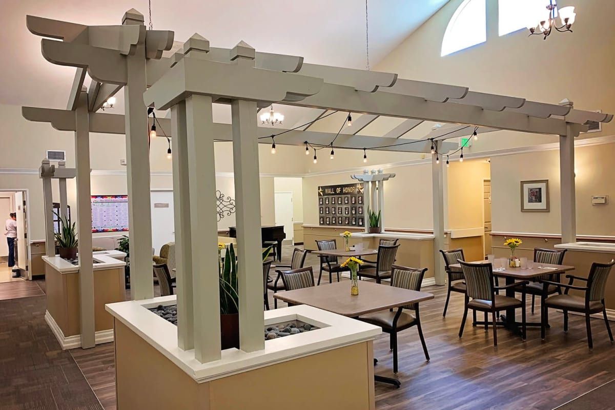 A cozy dining area with tables and chairs, complemented by indoor plants and warm lighting.
