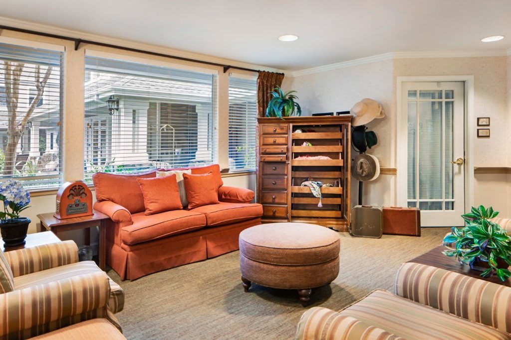 A cozy living room with a red sofa, armchairs, and a stylish bookshelf.
