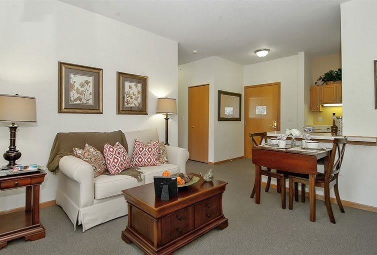 A cozy living room with a sofa, coffee table, and nearby dining area.