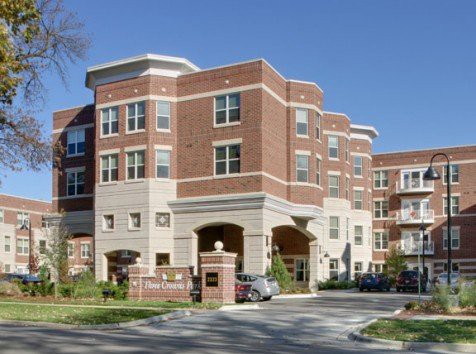 A modern brick residential apartment building with multiple stories and large windows.