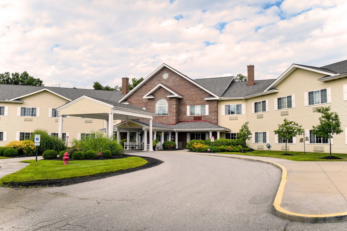 A large residential building with a landscaped driveway.
