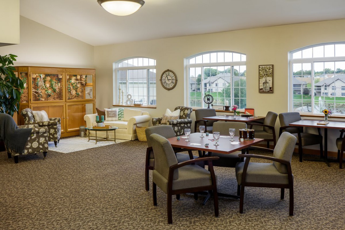 A cozy living room with a seating area and large windows allowing natural light to fill the space.