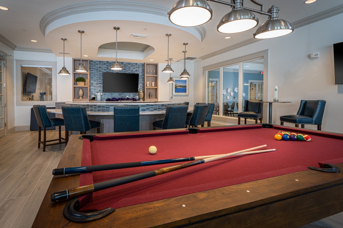 A stylish billiard room featuring a red pool table and modern decor.