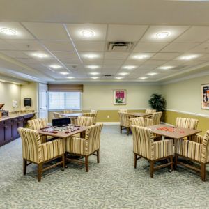 A well-lit conference room with multiple tables and chairs, ideal for meetings.