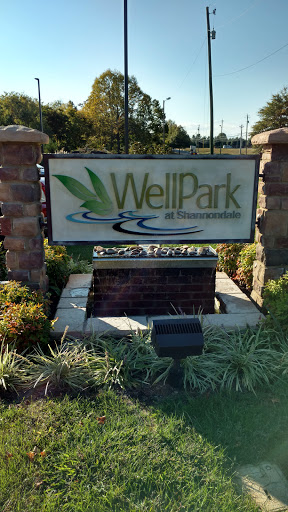 Entrance sign of WellPark, surrounded by lush landscaping.