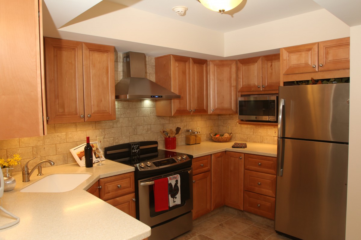 A modern kitchen with wooden cabinets and stainless steel appliances.
