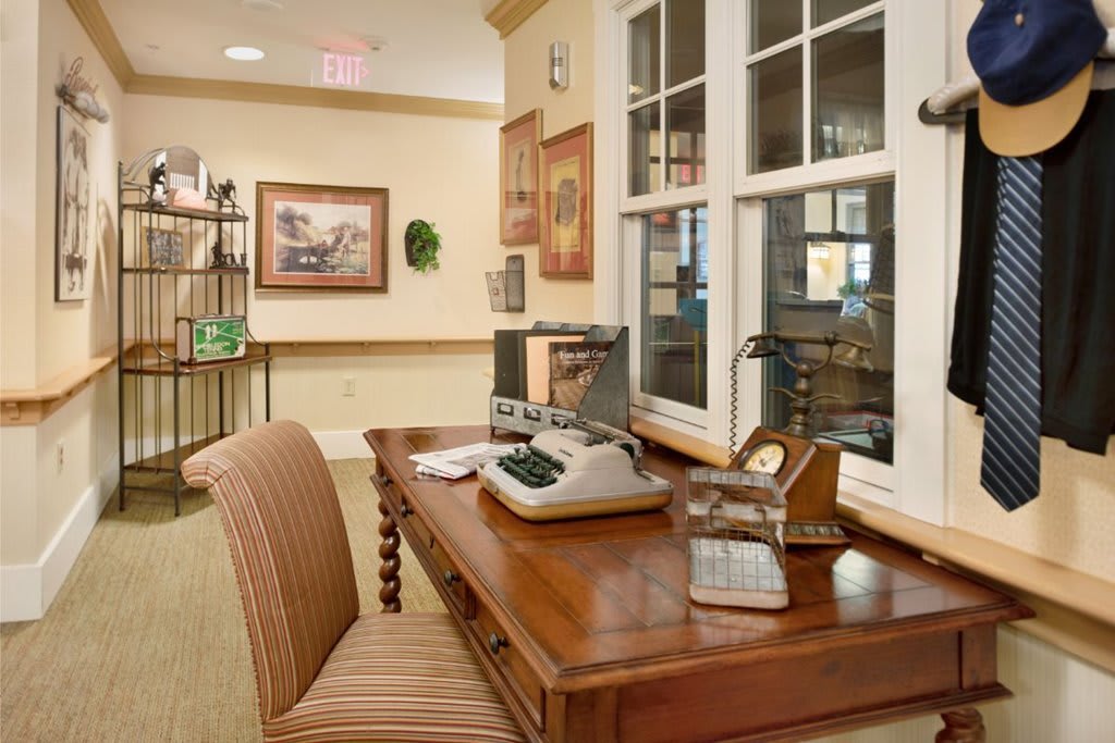 A cozy office space with a wooden desk, vintage typewriter, and bookshelf.