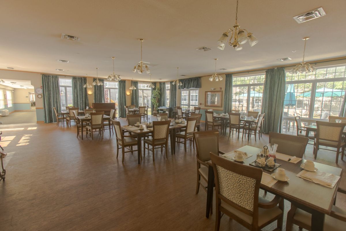 A spacious and elegantly decorated dining room with neatly arranged tables and chairs.