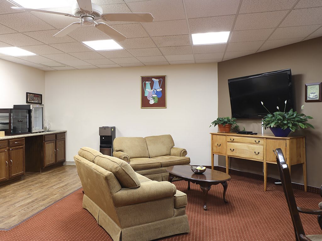 A cozy living room with sofas, a coffee table, and a television.