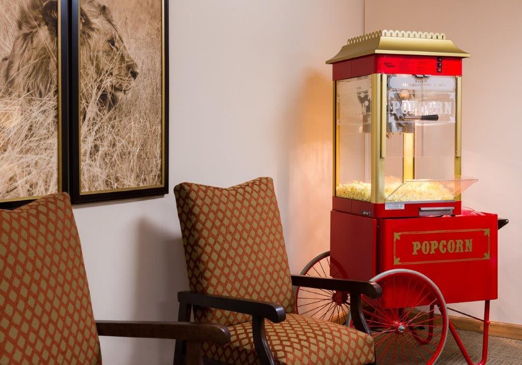 A cozy interior featuring a vintage popcorn machine and patterned chairs.