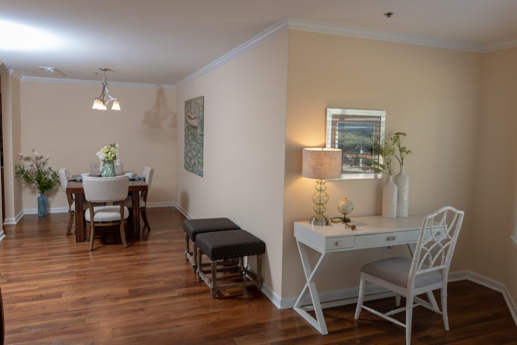 A modern living and dining area featuring a wooden floor, desk space, and elegant decor.