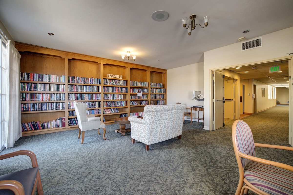 A cozy reading area with shelves full of books and comfortable seating.