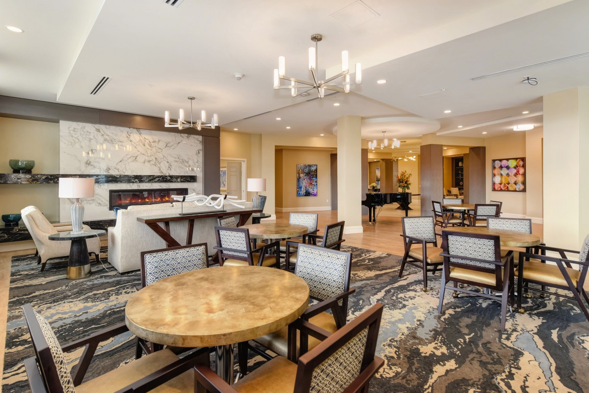 A modern lounge area with elegant furniture and chandeliers.