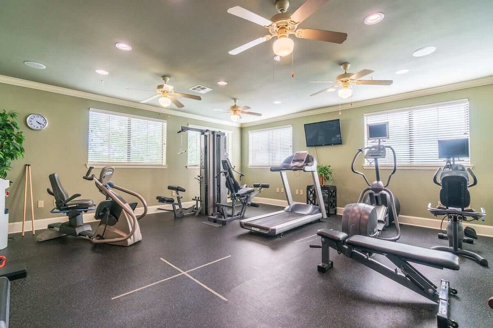 A well-equipped gym with various exercise machines and weights.