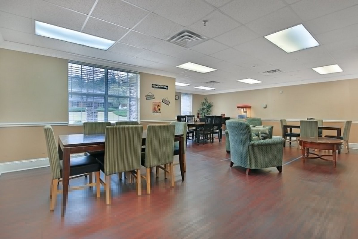A spacious community room with tables and chairs arranged for gatherings.