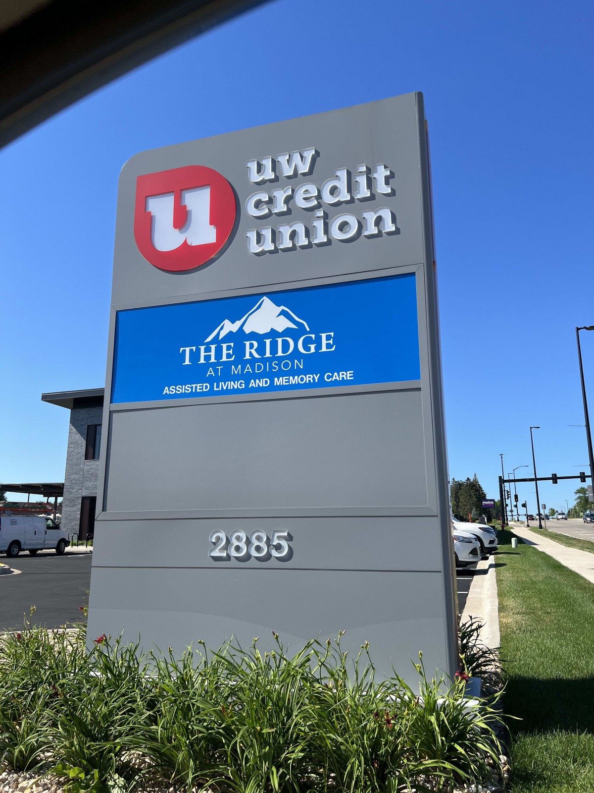A signboard displaying UW Credit Union and The Ridge located at 2885 on a sunny day.