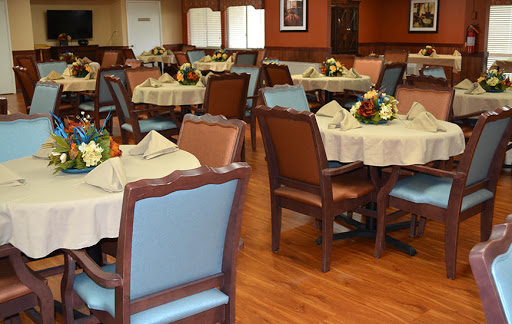 A beautifully arranged dining room featuring elegant tables and chairs, adorned with floral centerpieces.
